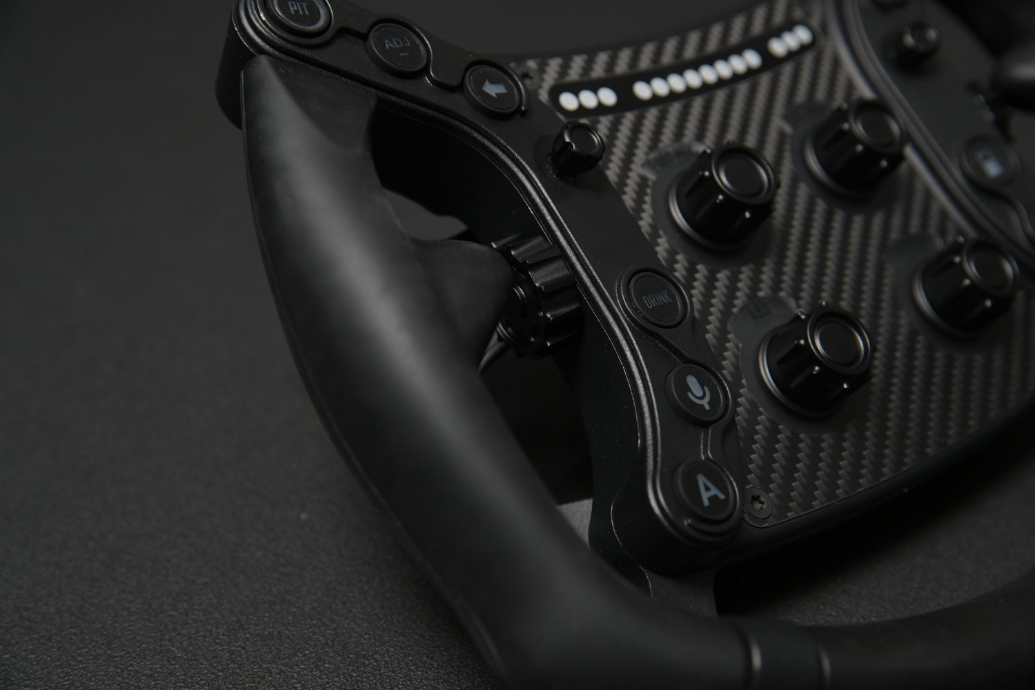 Close-up of a GTSL Pro steering wheel with controls on a dark background.