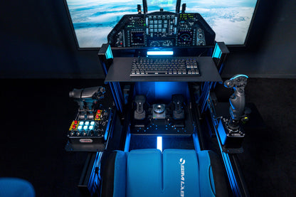 Flight sim cockpit with controls and screens in a dark room